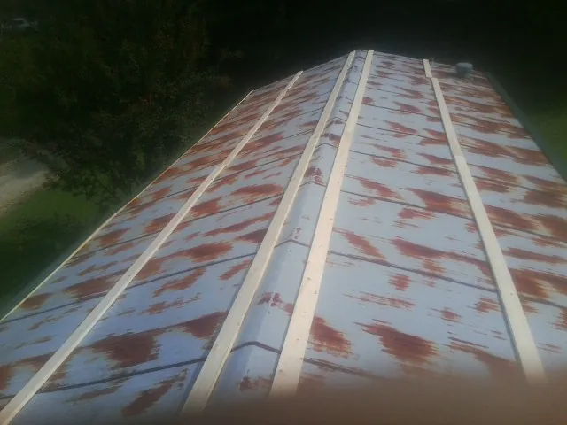 Rusted metal roof panels with new wood purlins before replacement — Storm Damage Roof Repair in Okolona by Roofing Brothers