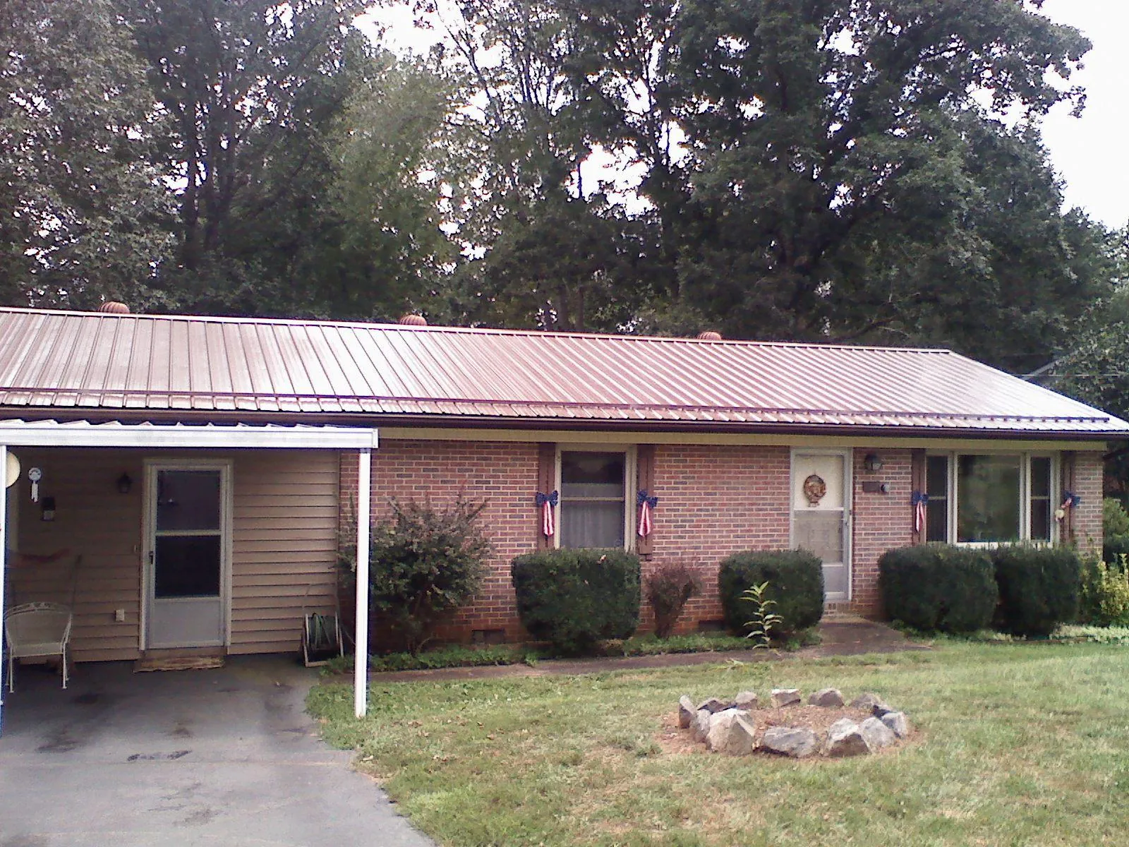 Bronze metal roof and carport on a brick ranch home — Roof Repair work by our crew in Okolona