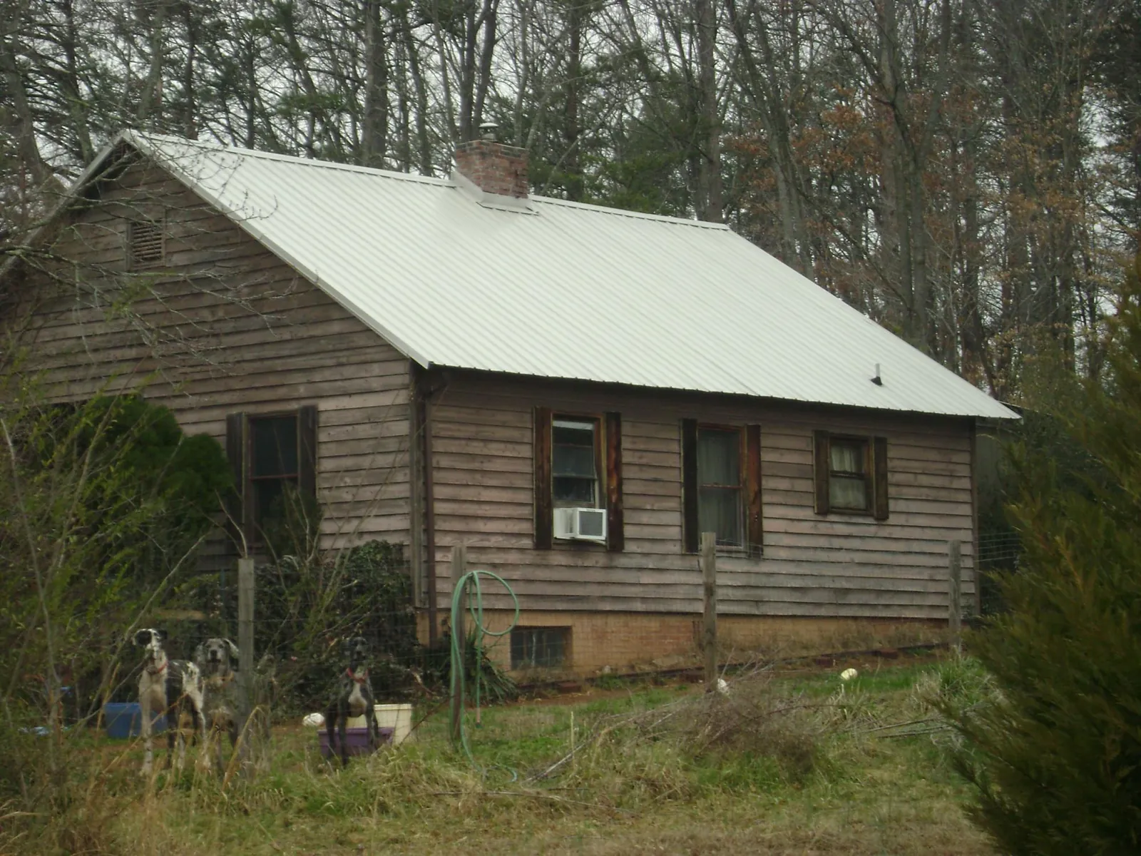 White metal roof on an old wood sided farmhouse, from a Metal Roof Installation job in Okolona